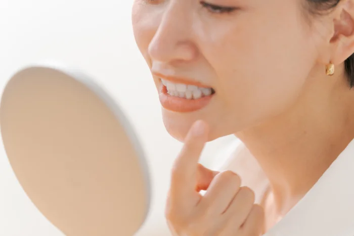 鏡で歯並びを確認する女性