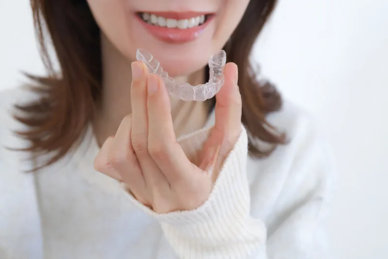 マウスピースを手に持つ女性